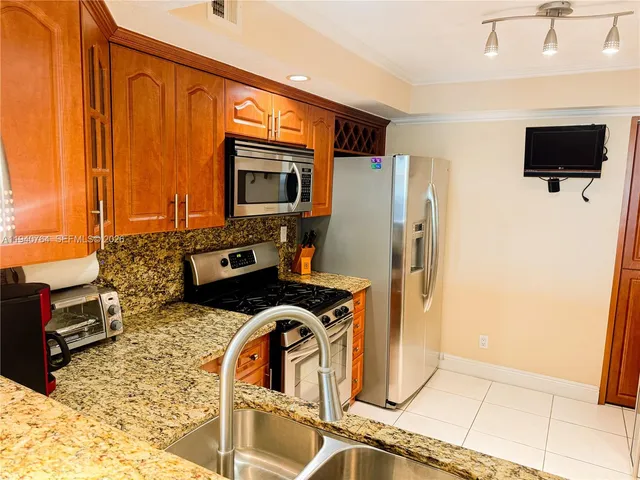 a kitchen with stainless steel appliances a stove a microwave and a refrigerator