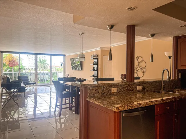a kitchen with granite countertop a table chairs stove and sink