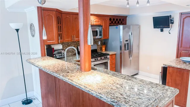 a kitchen with stainless steel appliances granite countertop a refrigerator and a sink