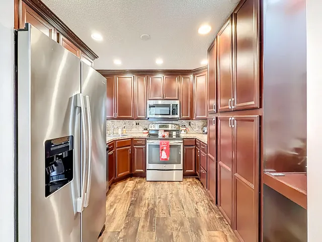 a kitchen with stainless steel appliances granite countertop a refrigerator stove and sink