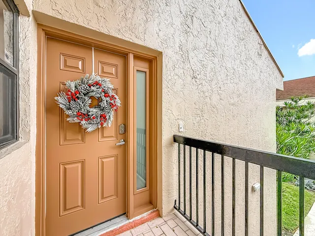 a front view of a house with a yard and large trees