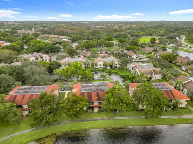 an aerial view of residential houses with outdoor space and lake view