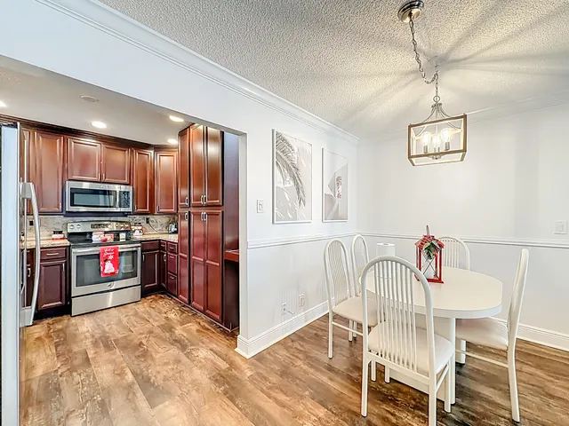 a view of a dining room with furniture wooden floor and chandelier