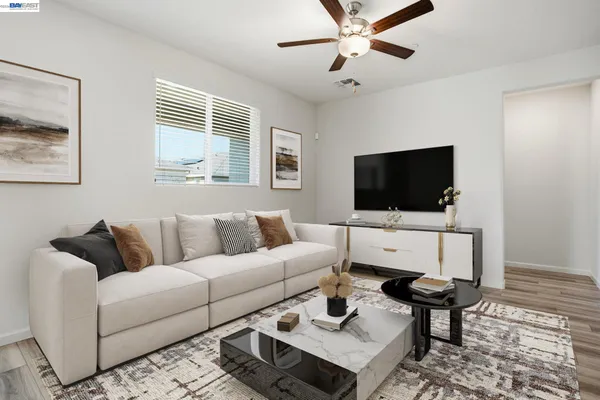 a living room with furniture a flat screen tv and a window