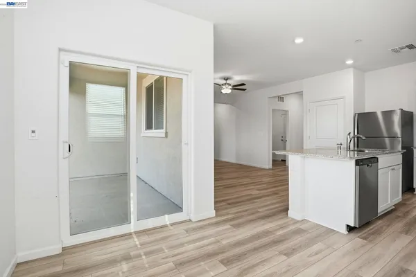 a kitchen with stainless steel appliances a refrigerator and wooden floor