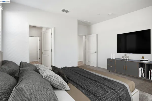 a bedroom with a bed and a flat screen tv on dresser and a flat screen tv