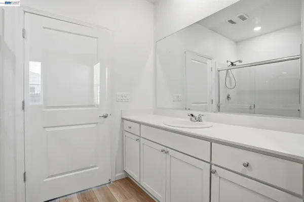 a bathroom with a shower sink and mirror