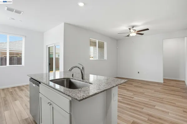 a kitchen with sink granite and white cabinets