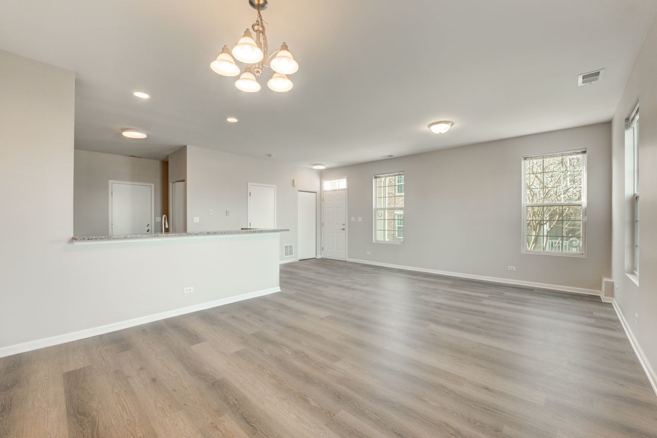 277 Springbrook Trail South Oswego, IL 60543 - Photo 11 of 28 an empty room with wooden floor and windows