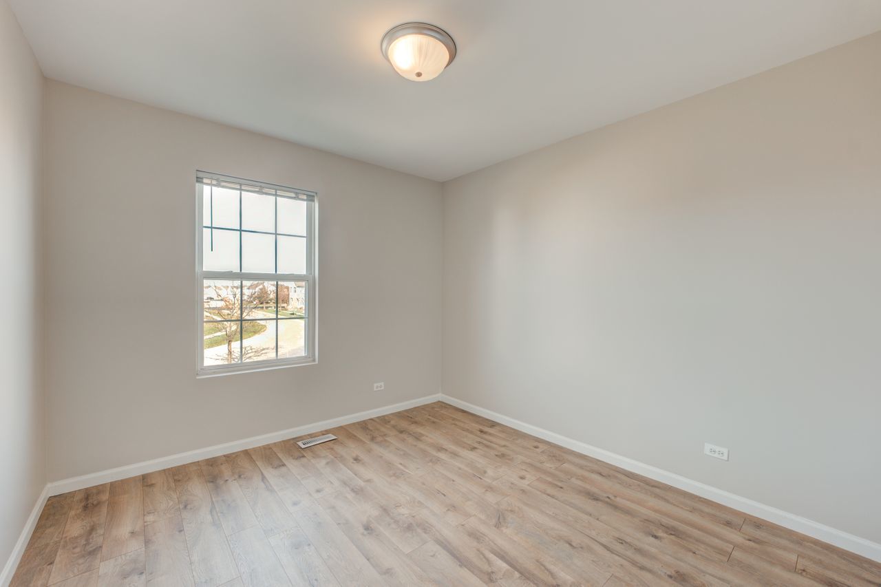 277 Springbrook Trail South Oswego, IL 60543 - Photo 15 of 28 an empty room with wooden floor and windows
