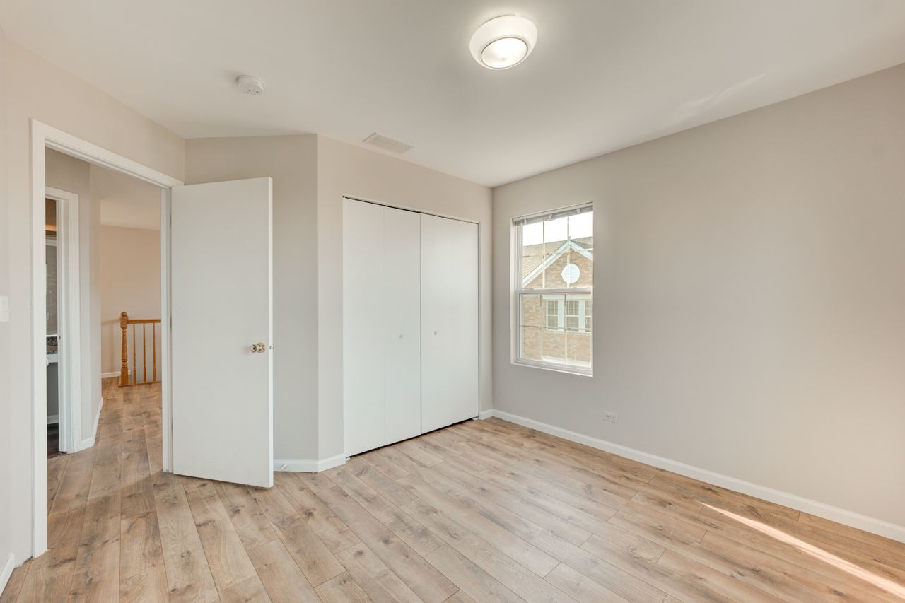 277 Springbrook Trail South Oswego, IL 60543 - Photo 20 of 28 a view of an empty room with wooden floor and a window