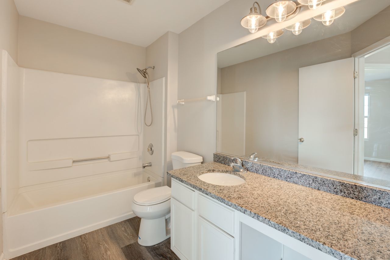 277 Springbrook Trail South Oswego, IL 60543 - Photo 25 of 28 a bathroom with a granite countertop sink a toilet and shower