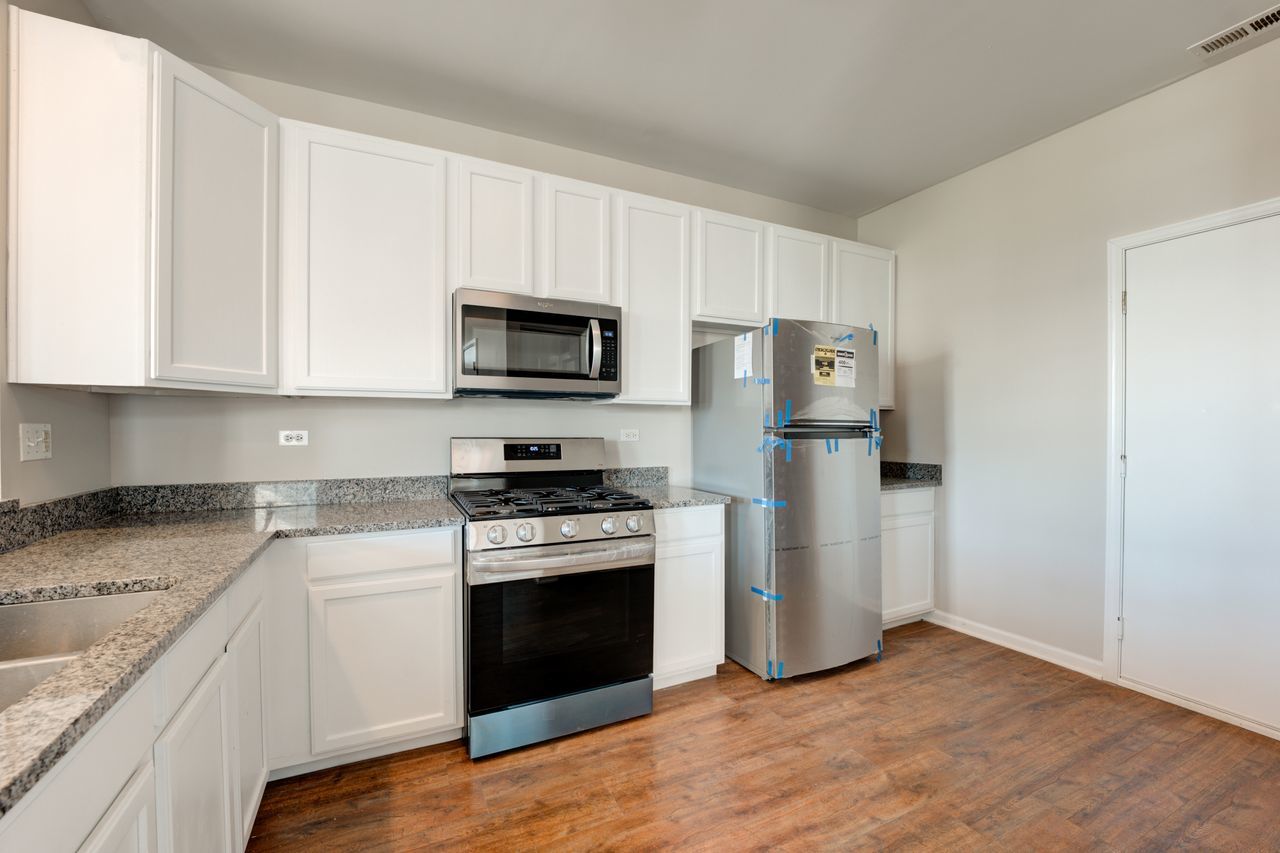277 Springbrook Trail South Oswego, IL 60543 - Photo 5 of 28 a kitchen with stainless steel appliances granite countertop a stove a refrigerator and a microwave