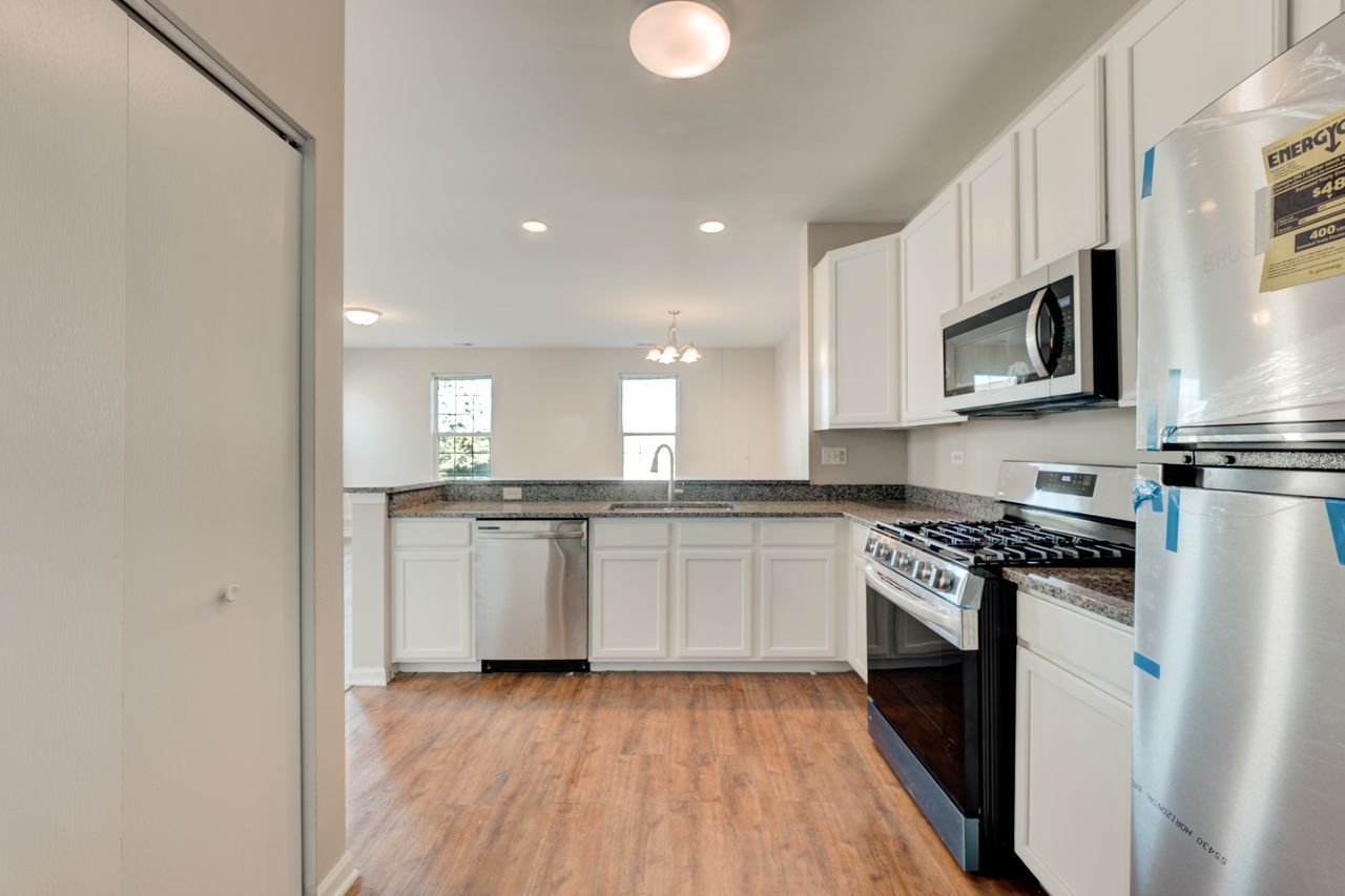 277 Springbrook Trail South Oswego, IL 60543 - Photo 6 of 28 a kitchen with stainless steel appliances granite countertop a stove a sink and a microwave