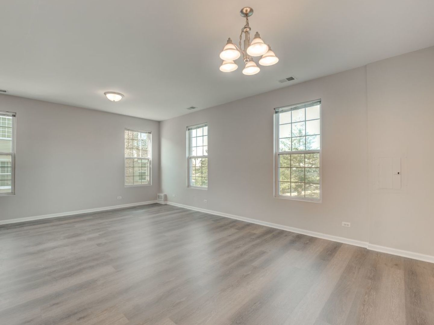 277 Springbrook Trail South Oswego, IL 60543 - Photo 7 of 28 an empty room with wooden floor and windows