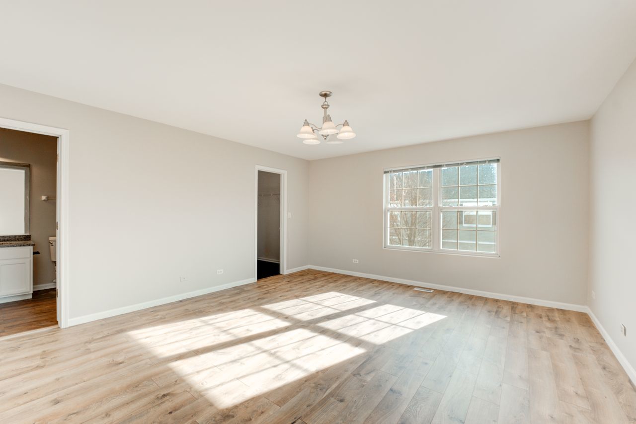 277 Springbrook Trail South Oswego, IL 60543 - Photo 10 of 28 a view of an empty room with wooden floor and a window