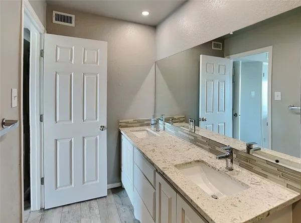 a bathroom with a granite countertop sink and a mirror