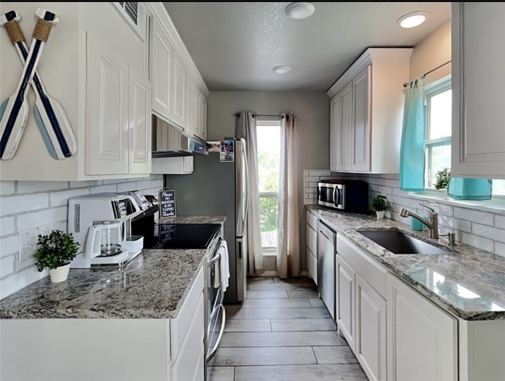 2003 North Fulton Beach Road, Unit 14 Rockport, TX 78382 - Photo 15 of 30 a kitchen with kitchen island granite countertop a sink stove and cabinets