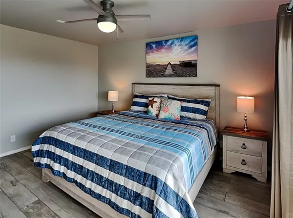 a bedroom with a bed and a lamp on dresser