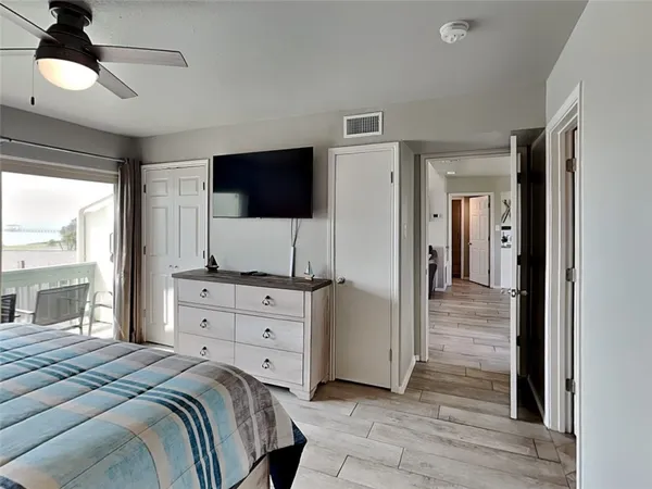 a bedroom with a bed and a flat tv screen on dresser
