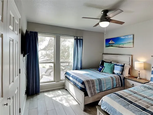 a bedroom with two beds chandelier and a window