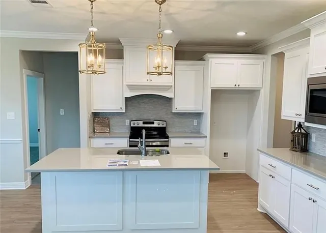 a kitchen with kitchen island granite countertop stainless steel appliances a sink stove and refrigerator