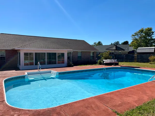 a view of a house with swimming pool and porch