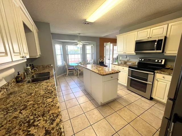 a kitchen with stainless steel appliances a stove sink microwave and cabinets