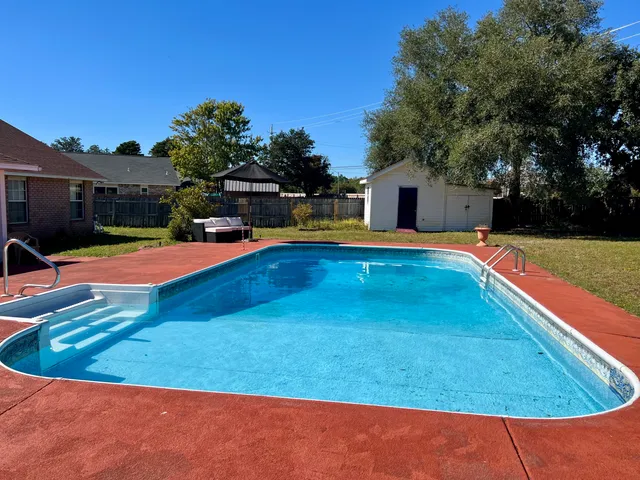 a view of a backyard with swimming pool