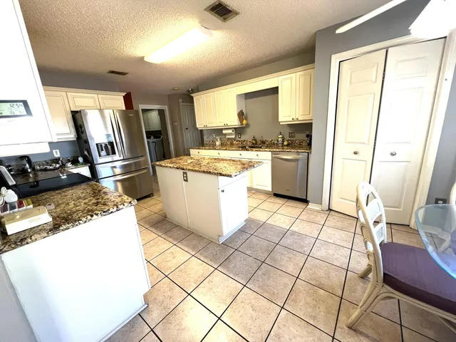 a kitchen with a stove a refrigerator and countertop