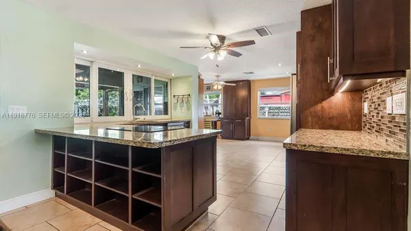 a kitchen with granite countertop a sink and a refrigerator