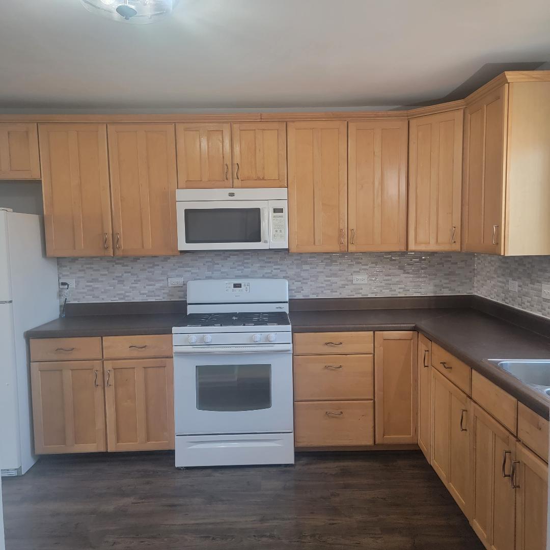 217 Pheasant Road Matteson, IL 60443 - Photo 6 of 27 a kitchen with stainless steel appliances granite countertop a stove a sink and a microwave