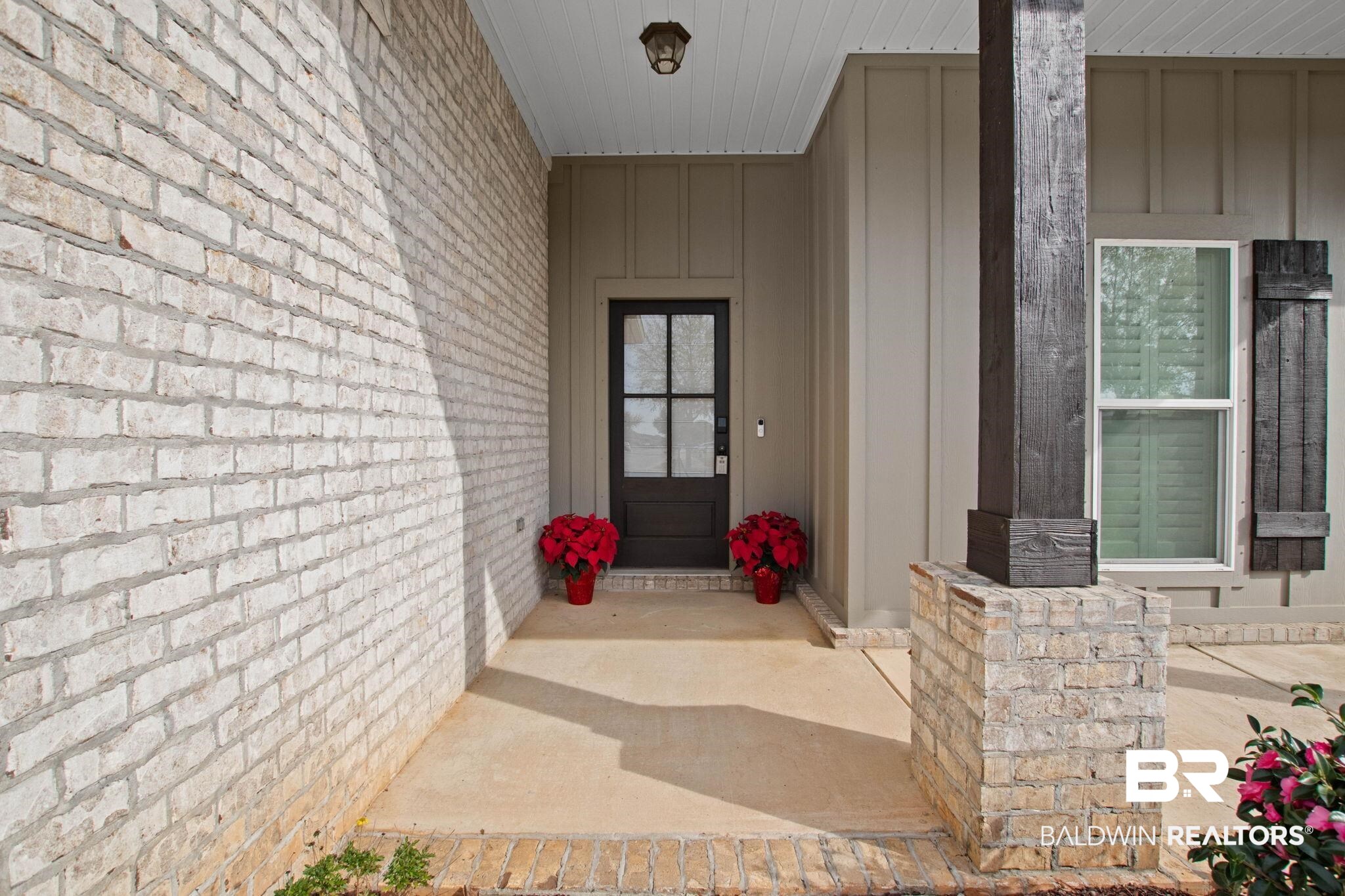 17376 Bankhead Boulevard Fairhope, AL 36532 - Photo 7 of 73 View of exterior entry with board and batten siding and covered porch