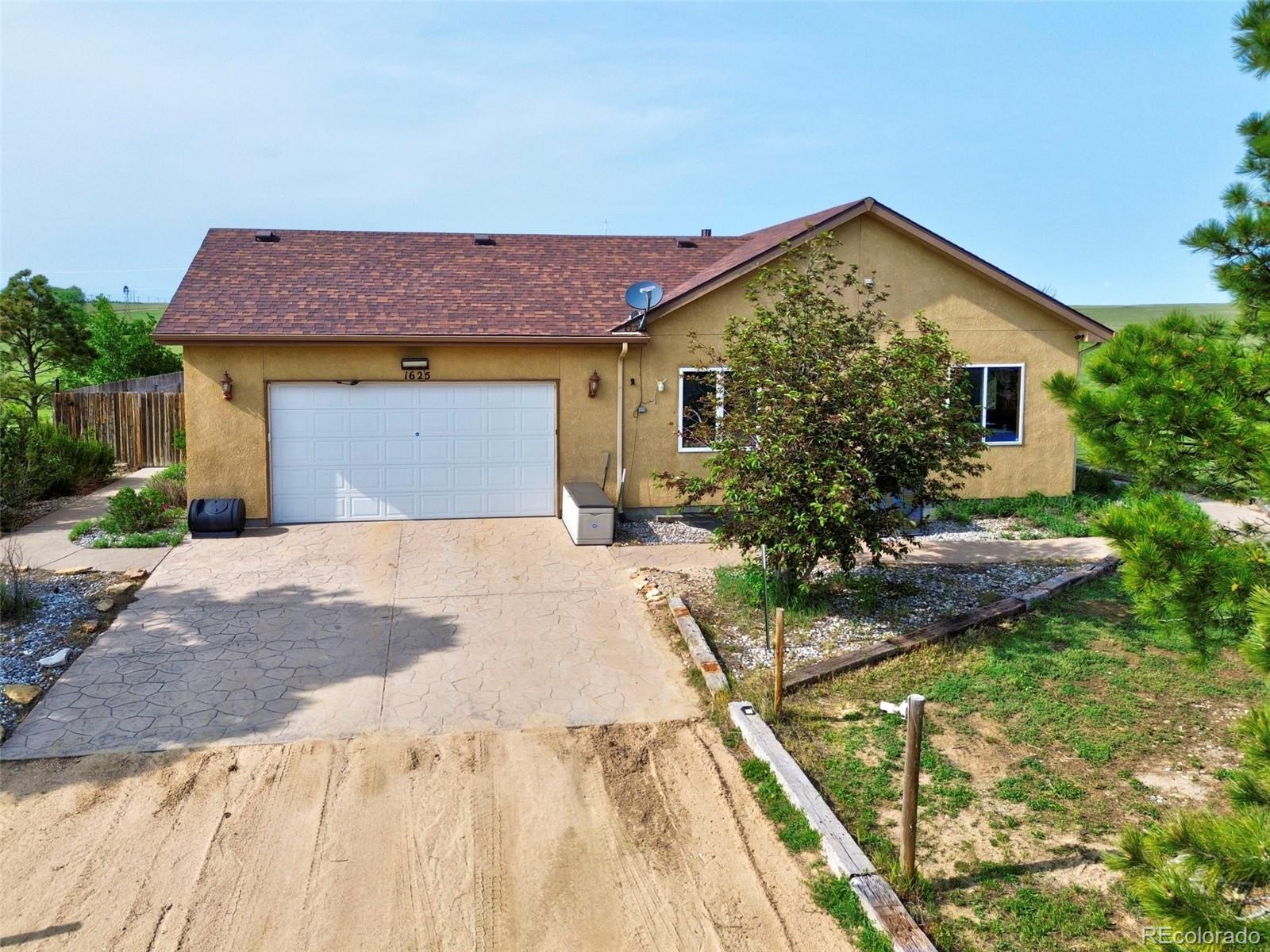 1625 North Yoder Road Yoder, CO 80864 - Photo 3 of 50 a front view of a house with garden