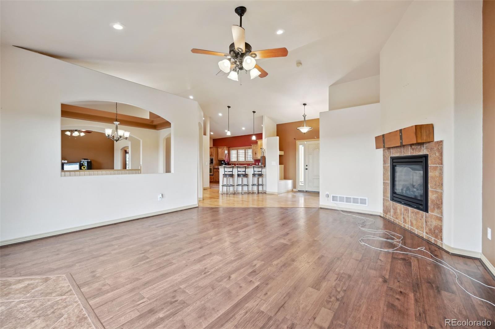 1625 North Yoder Road Yoder, CO 80864 - Photo 10 of 50 an empty room with a fireplace and chandelier fan