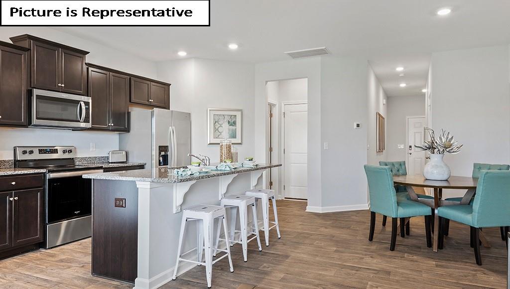 7120 North Mill Road Charlotte, NC 28216 - Photo 8 of 26 a kitchen with stainless steel appliances granite countertop a stove top oven a sink dishwasher a dining table and chairs with wooden floor