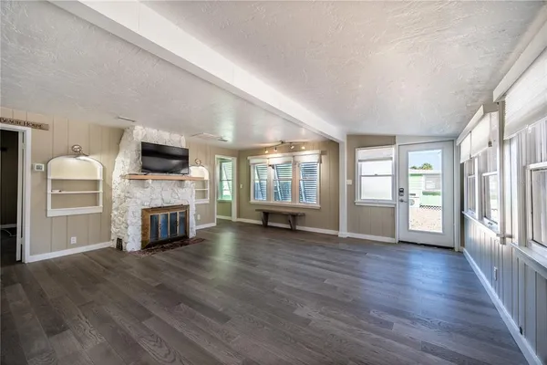 a view of a livingroom with a fireplace wooden floor and window