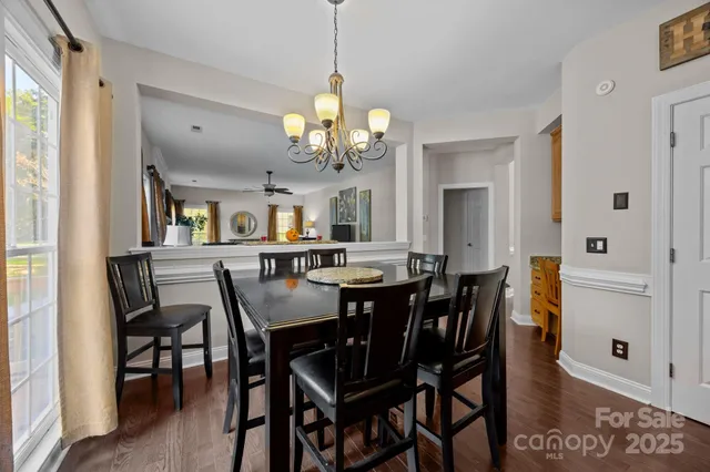 a kitchen with stainless steel appliances granite countertop a table chairs sink and cabinets