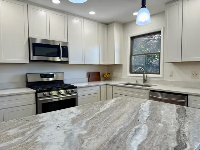 a kitchen with stainless steel appliances granite countertop a stove and a sink