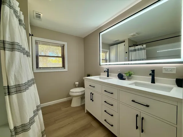 a bathroom with a granite countertop sink toilet and shower