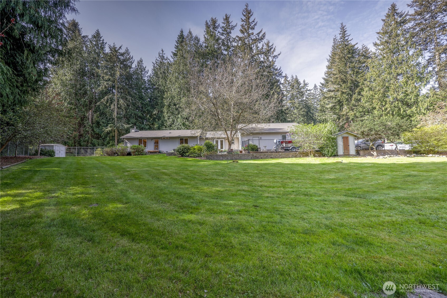 a view of a house with a big yard and sitting area
