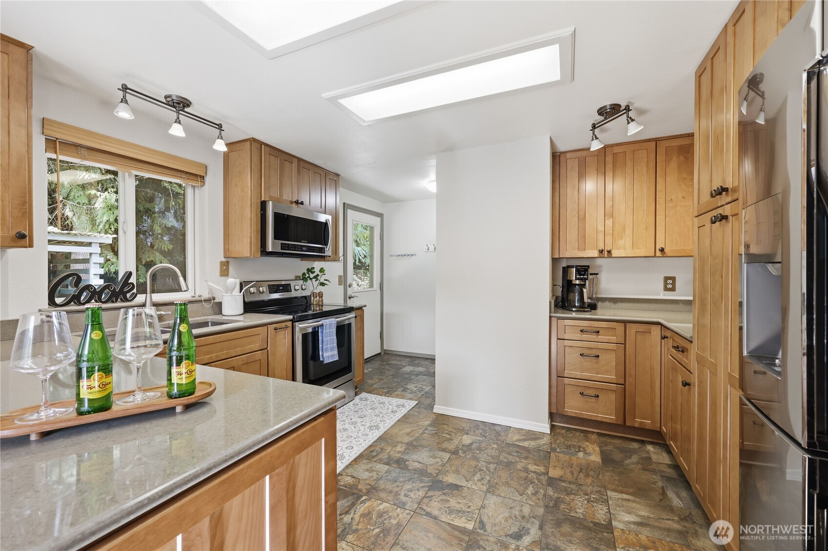 70 Salal Way Sequim, WA 98382 - Photo 14 of 36 a kitchen with granite countertop a refrigerator stove and sink