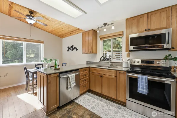 a kitchen with stainless steel appliances a stove a sink and a microwave