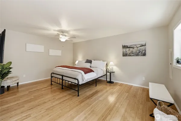 a bedroom with a bed and a potted plant on the dresser