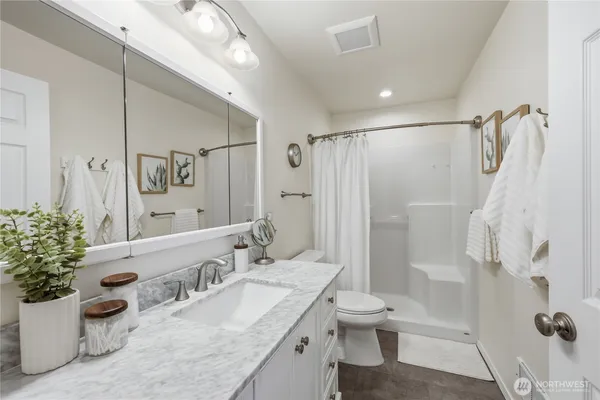 a bathroom with a granite countertop sink toilet and shower