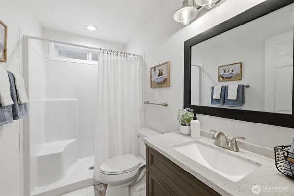 a bathroom with a granite countertop sink toilet and shower
