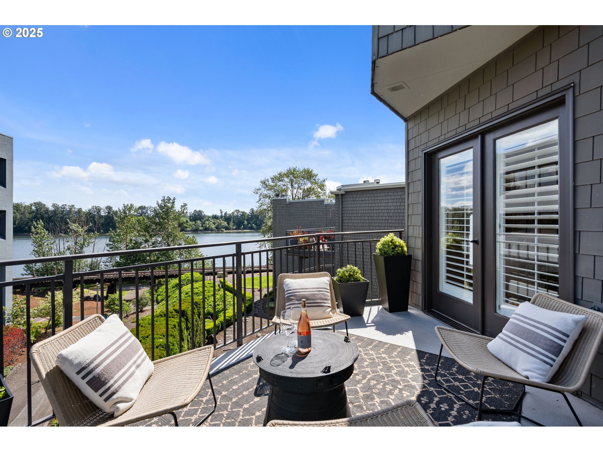 5620 South Riverside Lane, Unit 3 Portland, OR 97239 - Photo 32 of 41 a view of a balcony with two chairs and a potted plant