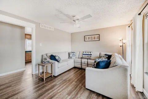 a living room with furniture and a wooden floor