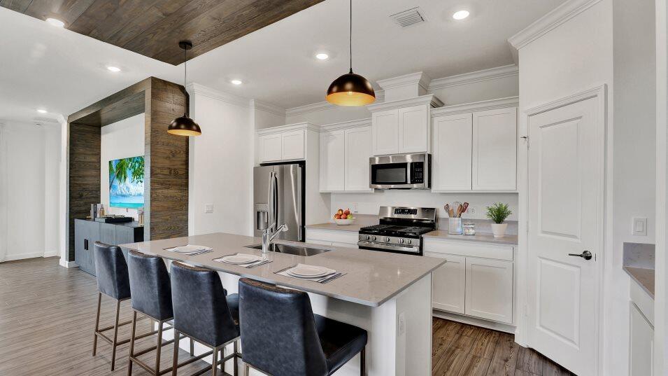 19788 Whispering Creek Road Loxahatchee, FL 33470 - Photo 2 of 14 a kitchen with stainless steel appliances kitchen island granite countertop a stove a sink a microwave a refrigerator and white cabinets with wooden floor