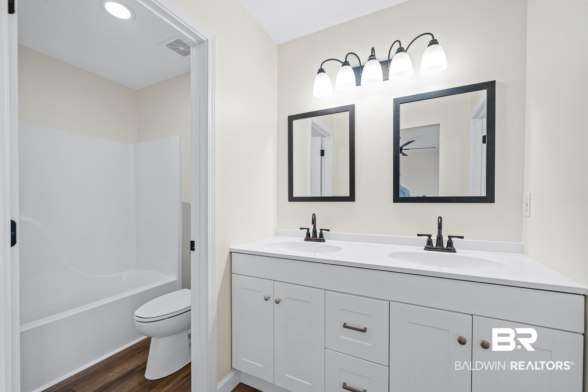 8921 Sherman Road Foley, AL 36535 - Photo 11 of 19 Full bathroom with double sink, shower / washtub combination, wood-type flooring, toilet, and large vanity